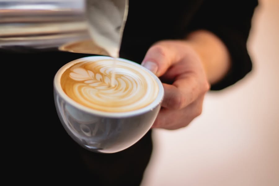 Pouring latte art at First Draft Coffee